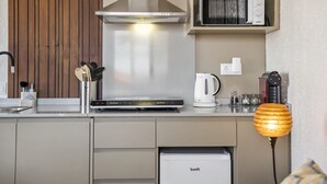 Una cocina moderna con microondas integrado, cafetera y lavavajillas compacto.