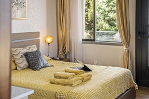 A neatly made bed with a laptop, a bedside lamp, and folded towels. - Cozy Apartment 3 by Homie (Porto Moniz)