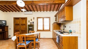 A kitchen with wooden cabinets, a dining table with chairs, and a window.