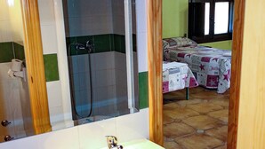 A bathroom with a sink, mirror, and shower.