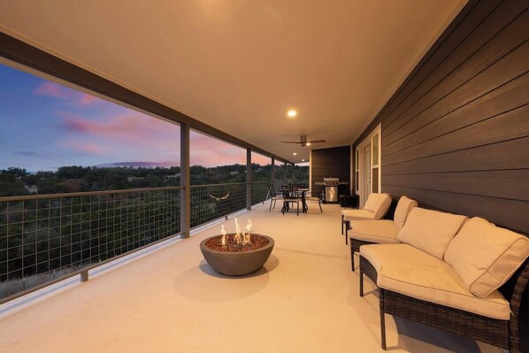 A balcony with a fire pit, outdoor furniture, and a view of the landscape.