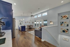 Un vaste espace de vie comprenant une table à manger, un canapé et un escalier menant à l’étage supérieur.