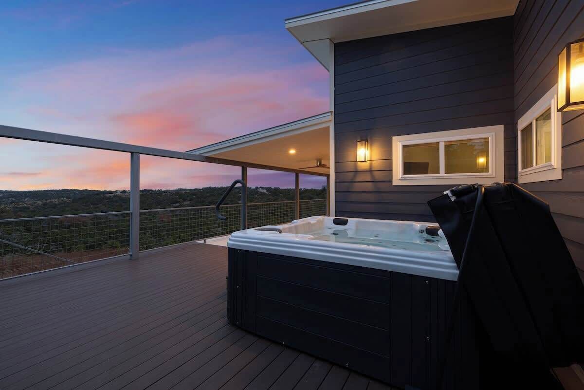 Un jacuzzi en una terraza de madera con vista al paisaje.