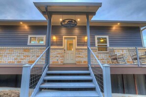 A two-story building with a stone facade, a wooden door, and a staircase leading to the entrance. - Esperanza Ranch w/Hot-tub, Fire pit, Gorgeous View (Fredericksburg)