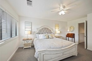 Classic bedroom with a large bed, bedside tables, and a ceiling fan.