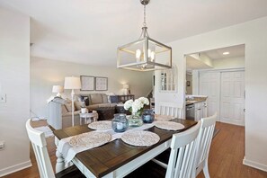 Enjoy meals in this stylish dining area with a wooden table, woven placemats, and a beautiful centerpiece.