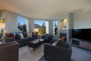Una sala de estar moderna con chimenea, televisor grande y asientos cómodos.