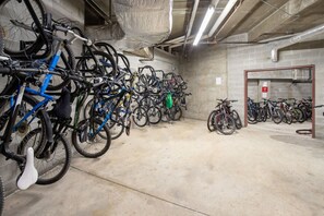 A multi-level indoor bike parking area with concrete walls and a tiled floor.