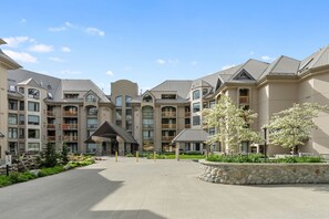 A multi-story hotel with a central courtyard, balconies, and a covered entrance.