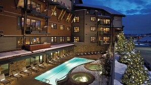 Un hotel con piscina, sillas de descanso y un árbol de Navidad.