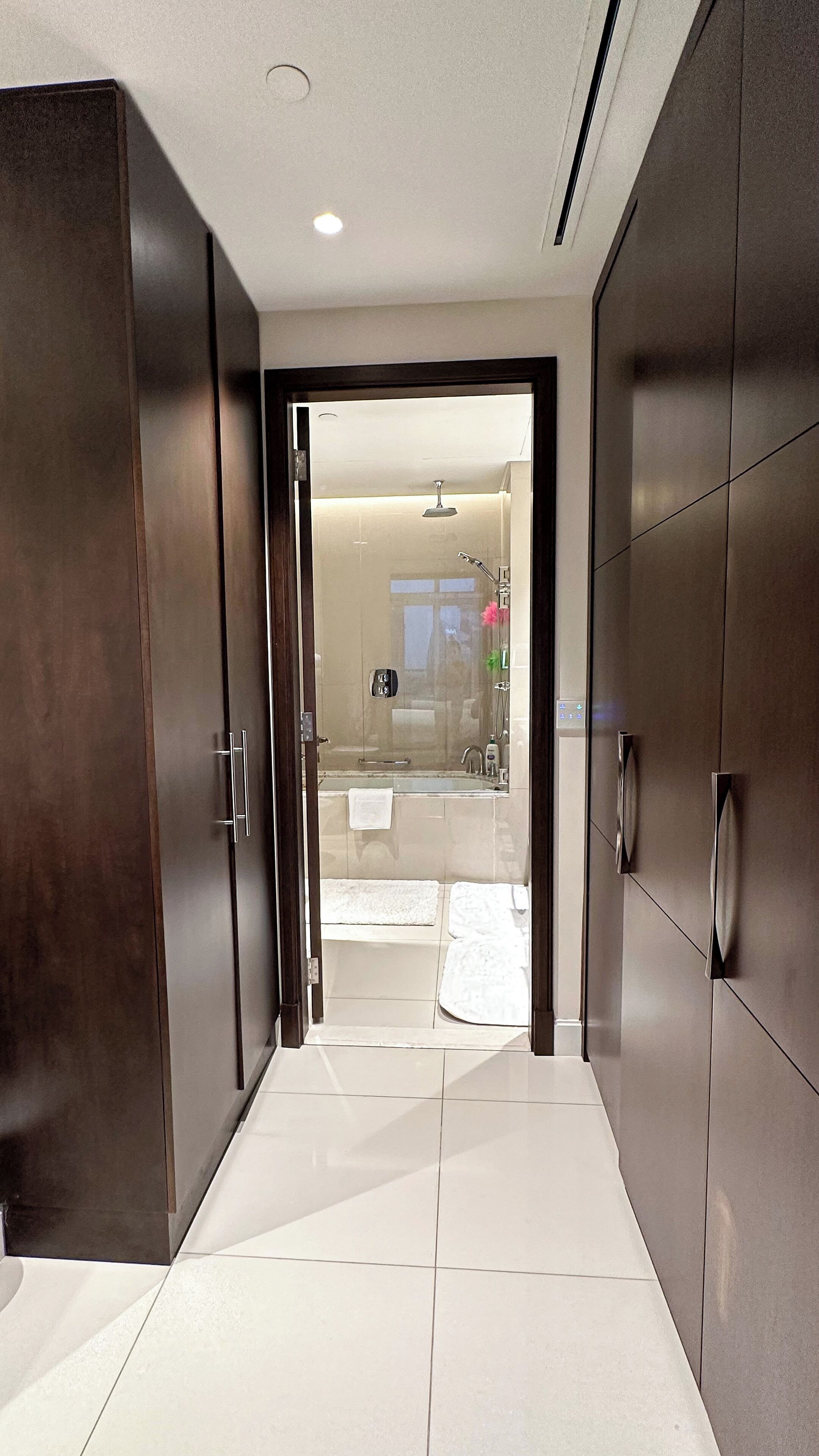Un baño moderno con cabina de ducha de vidrio, inodoro a la vista y un perchero para toallas.