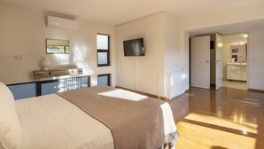 A bedroom with a bed, bedside table, and a TV mounted on the wall. - Agras 41·Spacious 4bdr Townhouse with Monumental V (Athens)