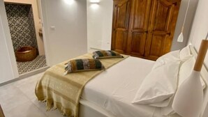 A bedroom with a bed, a wooden wardrobe, a bedside table, and a small chair. - BED&BIKEITALA ANGUILLARA SABAZIA AL BORGO - House in the village on the shores of the lake   (ANGUILLARA SABAZIA)