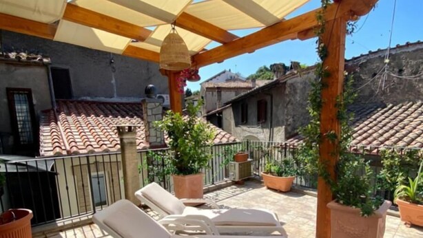 A covered patio with lounge chairs and potted plants. - BED&BIKEITALA ANGUILLARA SABAZIA AL BORGO - House in the village on the shores of the lake   (ANGUILLARA SABAZIA)