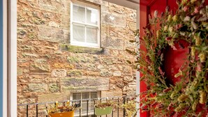A stone building with a window and a red door. - Little Haven | St Andrews Town Centre (St Andrews)