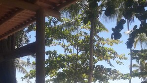 A poolside area with a table, chairs, and umbrellas. - Pousada Conchas Do Mar (Cairu)