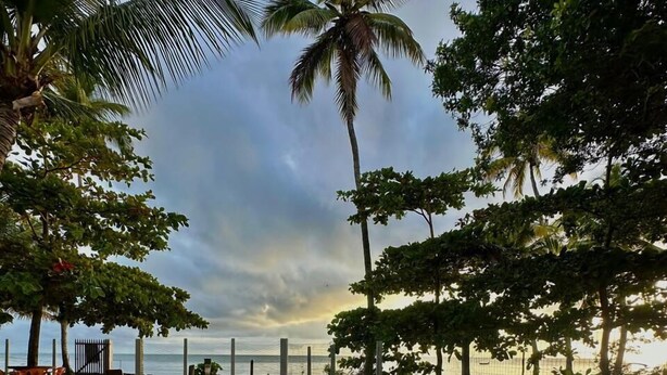 A swimming pool with a view of the sea and palm trees. - Pousada Conchas Do Mar (Cairu)