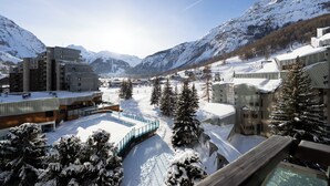 A snow-covered mountain resort with modern buildings, a ski slope, and a pool area. - Beautiful renovated apartment (Val-d'Isère)