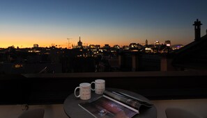 A balcony with two white mugs, a magazine, and a remote control.