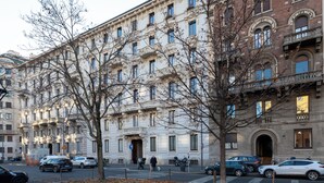 Un edificio a più piani con architettura classica, caratterizzato da balconi decorati e ampie finestre.