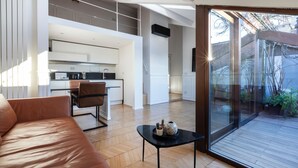 Un appartamento moderno con cucina, zona pranzo e un balcone con piante.