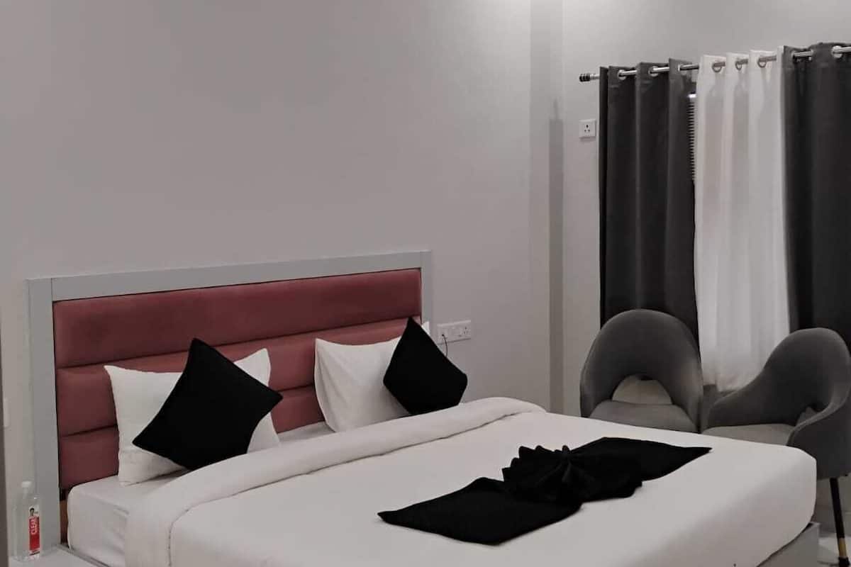 A modern bedroom with a large bed, a red headboard, and a ceiling fan.