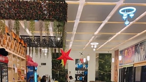 A restaurant with booths, high tables, and a counter area. There are balloons and a 'Happy Birthday' sign. - Aastha Guest House (Roorkee)