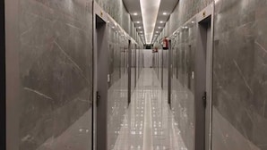 A long, narrow hallway with marble walls and floors, leading to multiple doors. - Aastha Guest House (Roorkee)