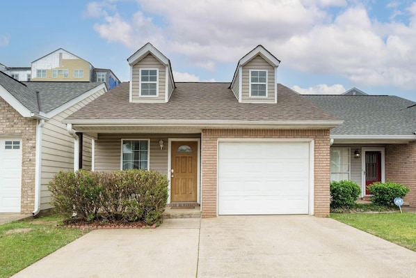 A single-story house with a front garage, a small porch, and a sloped roof.