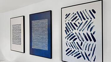 Tres obras de arte enmarcadas sobre una pared blanca.