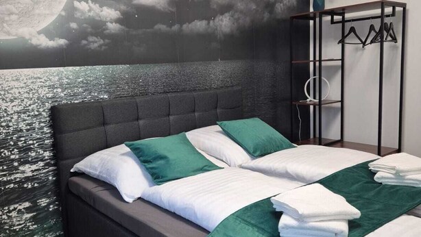 Un dormitorio con cama, armario y un mural en la pared.