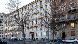 Un immeuble à plusieurs étages, doté d’une architecture classique, avec des balcons richement décorés et de grandes fenêtres.