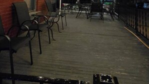 An outdoor patio area with wooden ceiling, hanging plants, and outdoor seating. - Historical Studio Apt - Walk to All of Downtown (Bay City)