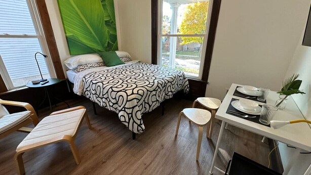 A bedroom with a bed, a desk, and a chair. - Fun & Functional Studio Apt (Bay City)