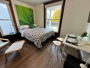 A bedroom with a bed, a desk, and a chair. - Fun & Functional Studio Apt (Bay City)