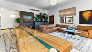Un salon moderne avec une table à manger en bois, des canapés en cuir et une grande fenêtre.
