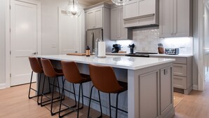 A modern kitchen with a large island, bar stools, and stainless steel appliances. - Pet-Friendly Manor on Bourbon Trail, Pools, Golf Local Dining, Fully Loaded (Prospect)