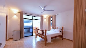 A bedroom with a wooden bed, a ceiling fan, and a small desk with a chair. - Diani Luxe Villa (Diani Beach)
