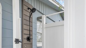 A wooden door with a black handle and a white gate.