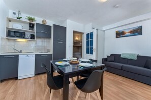 A compact living space with a kitchenette, dining area, and a sofa.