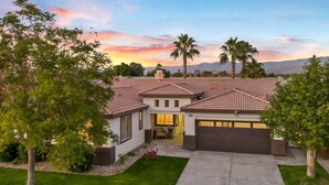 A modern two-story house with a tiled roof, a garage, and a well-maintained lawn. - NEW Lush Luxury Living-Heated Pool/Spa Included. Walking distance to Coachella (Indio)