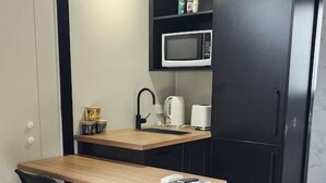 A compact kitchenette with a microwave, kettle, and coffee maker. - Enchanting Tiny Home in Vibrant Dickson (Dickson)