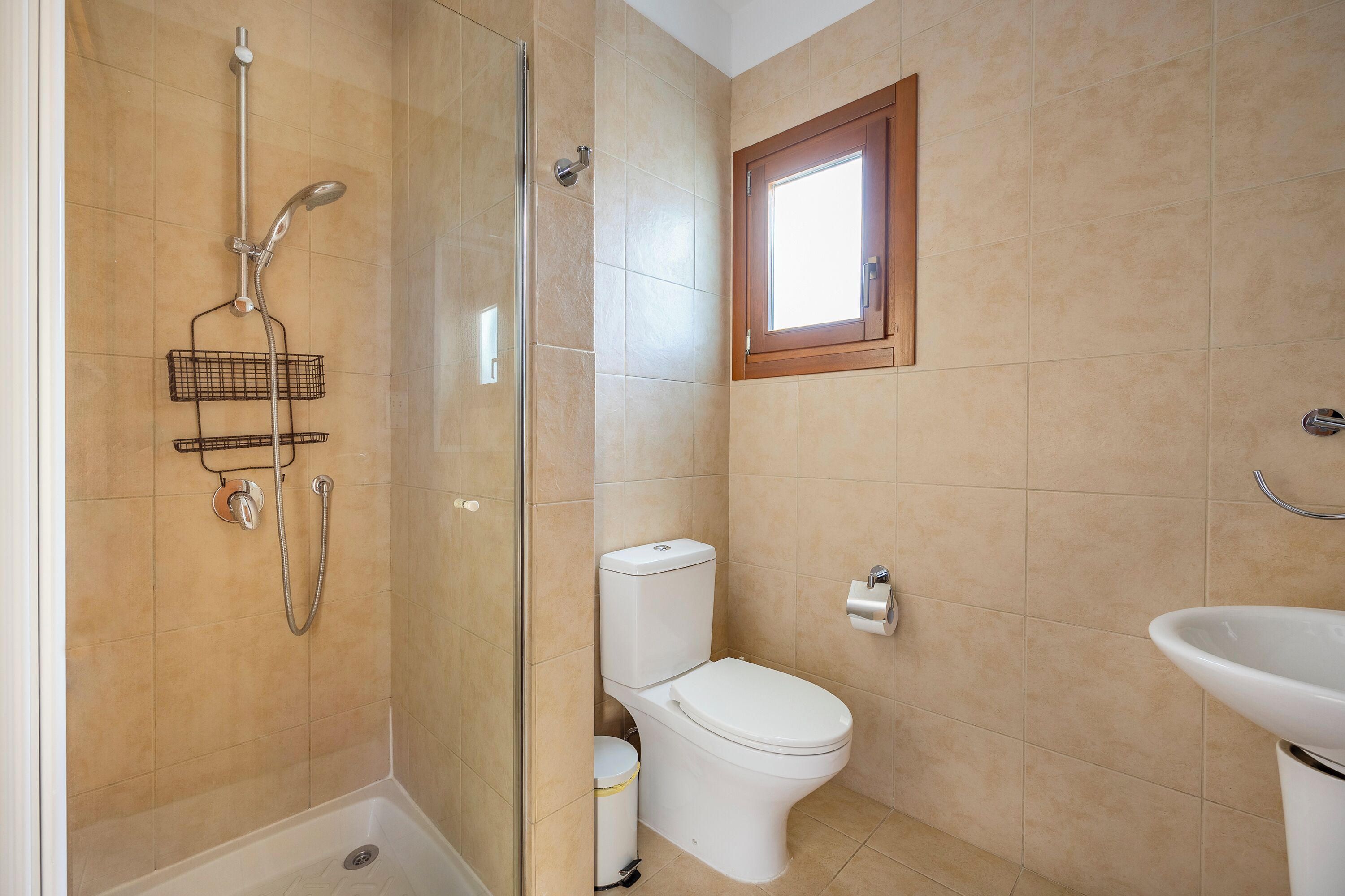 Une salle de bain avec une douche à parois de verre, des toilettes et un lavabo.