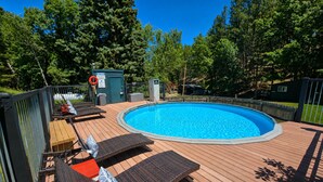 A swimming pool with lounge chairs and a deck. - The Golden Nugget Cabin (Keystone)