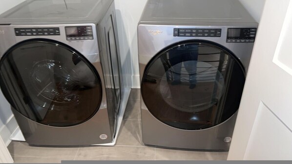 Two front-loading washing machines in a laundry room.