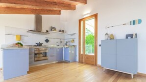 Una cocina moderna con vigas de madera, horno empotrado y un ventanal grande.