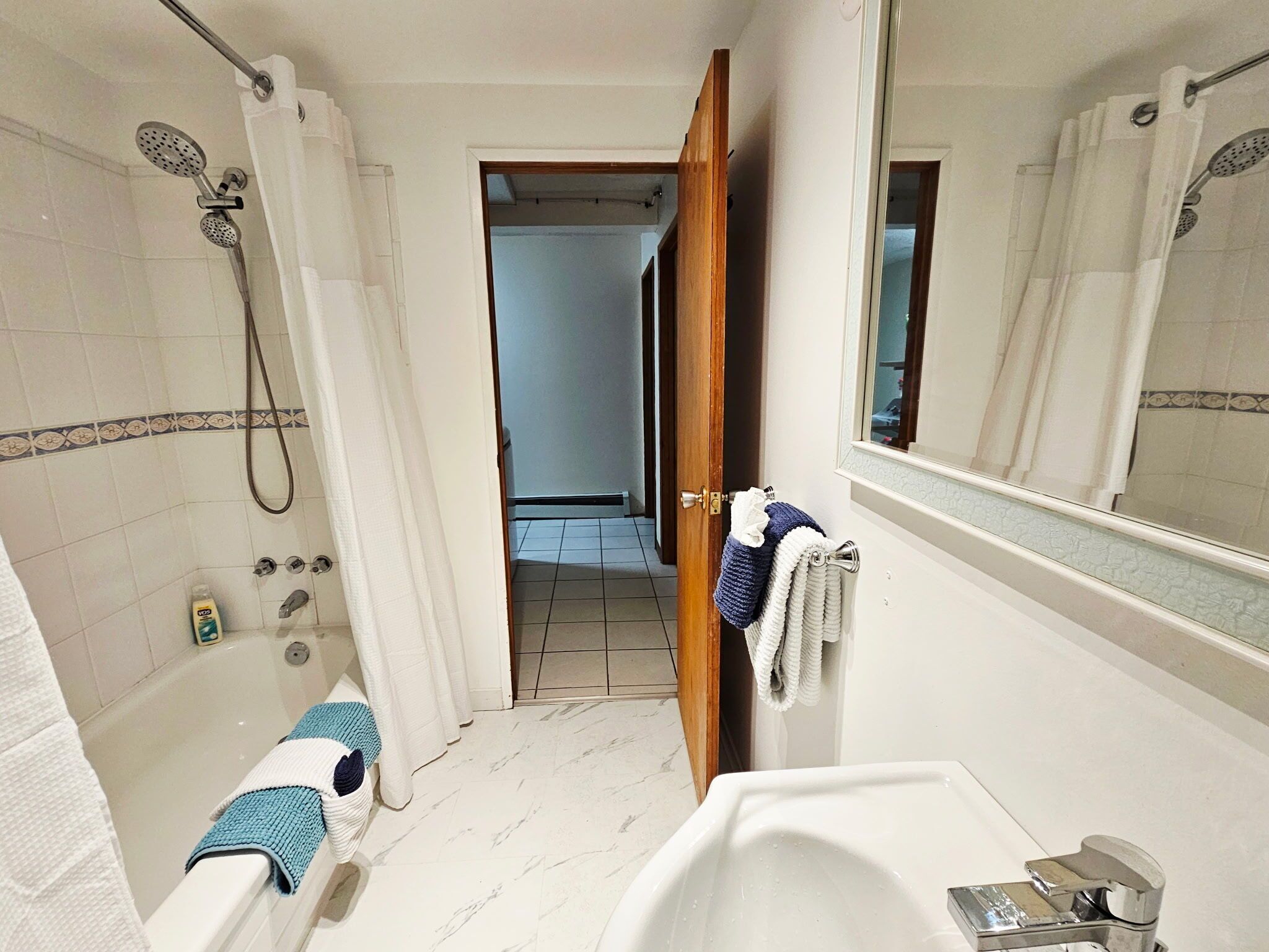 Un baño con bañera, ducha y espejo.