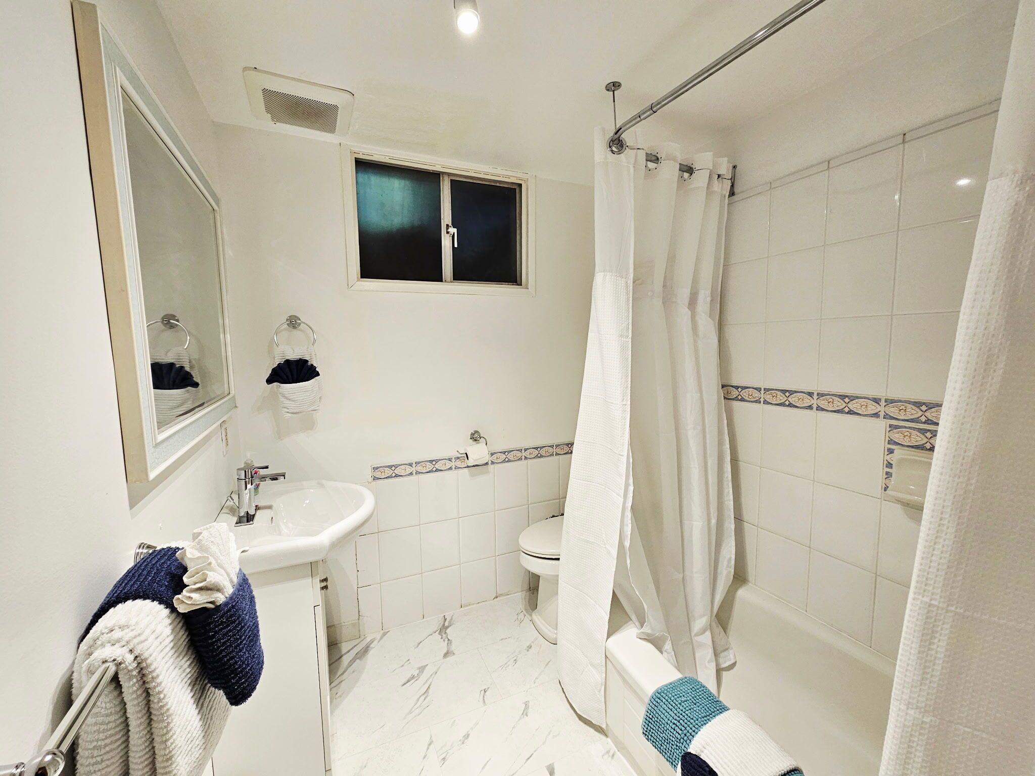Une salle de bain avec un lavabo, des toilettes et une douche.