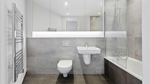 A modern bathroom with a toilet, sink, and shower. - Bejoux Court - Apt 1 (Harrow)