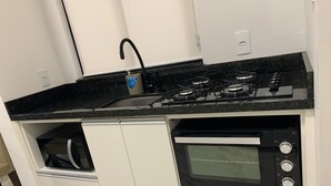 Kompakti keittiö, jossa on sisäänrakennettu uuni, mikroaaltouuni ja kaasuliesi.